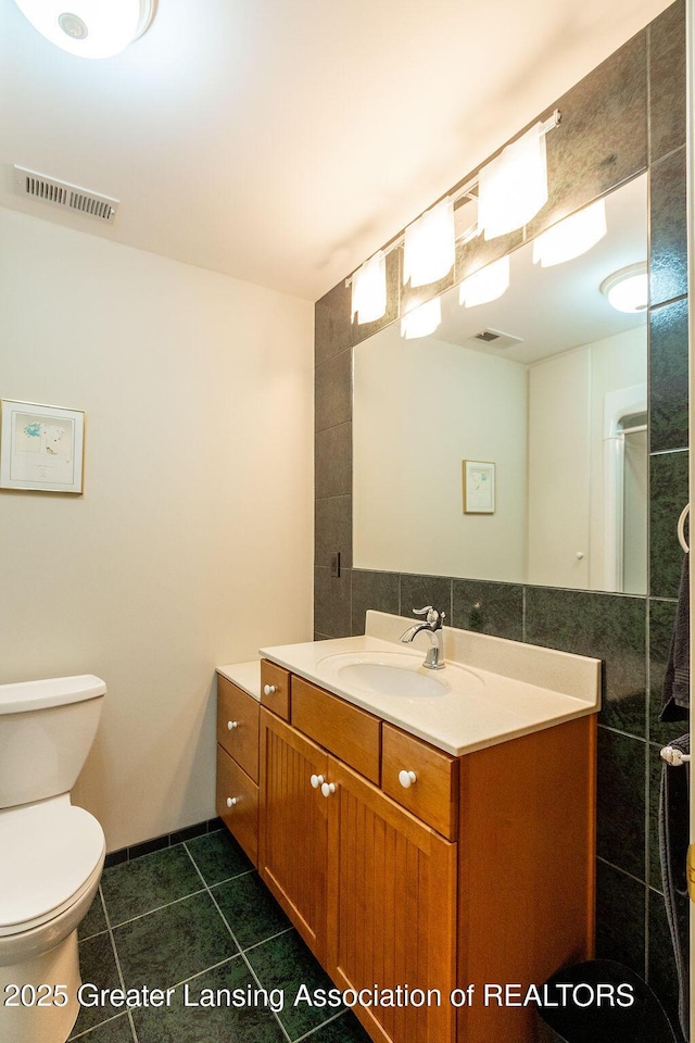 4001 Sierra Hts, Holt, MI 48842 - bathroom featuring vanity, tile patterned flooring, tile walls, and decorative backsplash