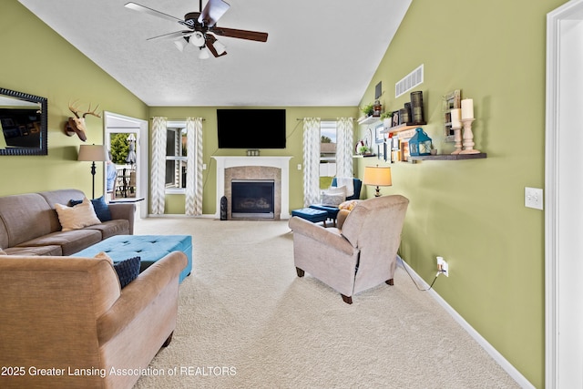 3913 Danbridge Dr, Lansing, MI 48906 - carpeted living area with lofted ceiling, a ceiling fan, and a fireplace with flush hearth