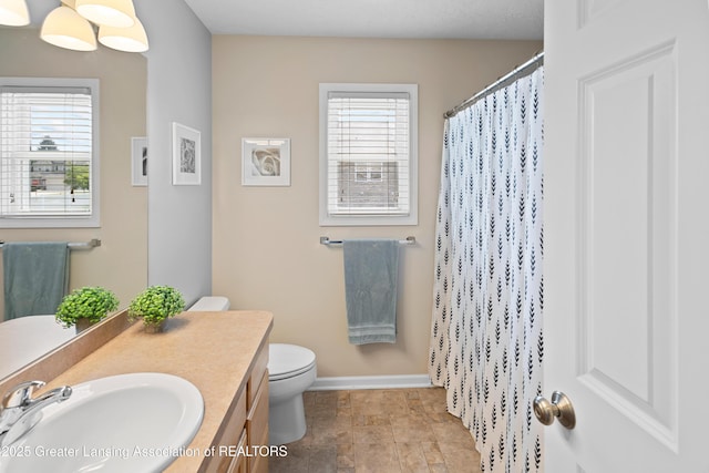 3913 Danbridge Dr, Lansing, MI 48906 - full bath with plenty of natural light, vanity, stone finish floors, and a shower with curtain