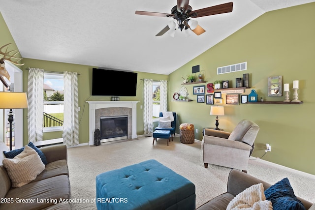 3913 Danbridge Dr, Lansing, MI 48906 - carpeted living area with lofted ceiling, a ceiling fan, and a fireplace with flush hearth