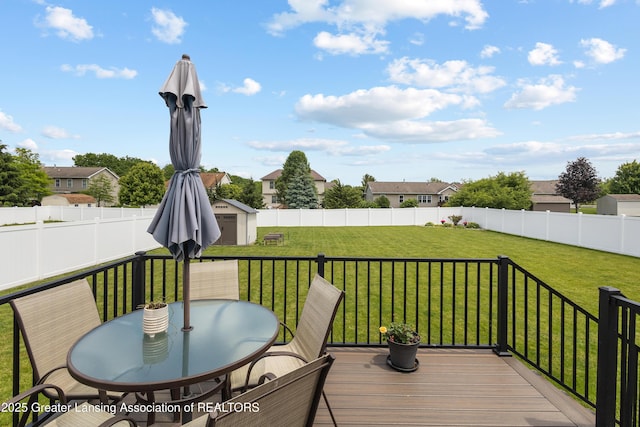 3913 Danbridge Dr, Lansing, MI 48906 - wooden deck featuring a storage unit, a fenced backyard, outdoor dining area, and a residential view