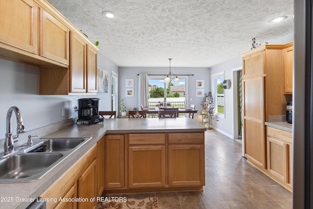 3913 Danbridge Dr, Lansing, MI 48906 - kitchen featuring a peninsula, decorative light fixtures, a chandelier, recessed lighting, and a textured ceiling