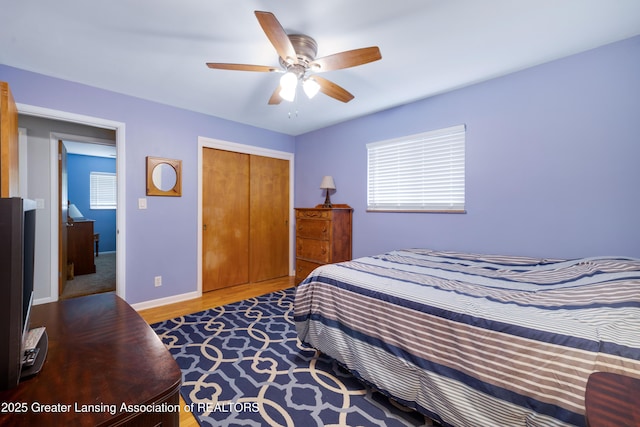425 S Holmes St, Lansing, MI 48912 - bedroom featuring a closet, wood finished floors, ceiling fan, and multiple windows