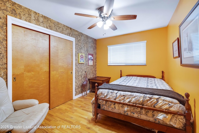 425 S Holmes St, Lansing, MI 48912 - bedroom with light wood-style flooring, a closet, a ceiling fan, and wallpapered walls