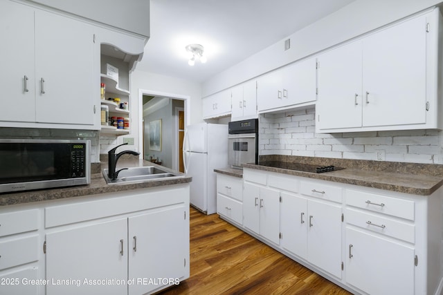 425 S Holmes St, Lansing, MI 48912 - kitchen featuring appliances with stainless steel finishes, white cabinets, dark countertops, backsplash, and open shelves