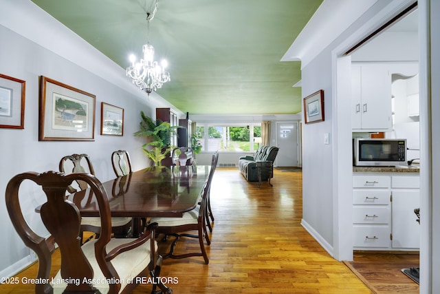 425 S Holmes St, Lansing, MI 48912 - dining area with light wood-type flooring and a chandelier
