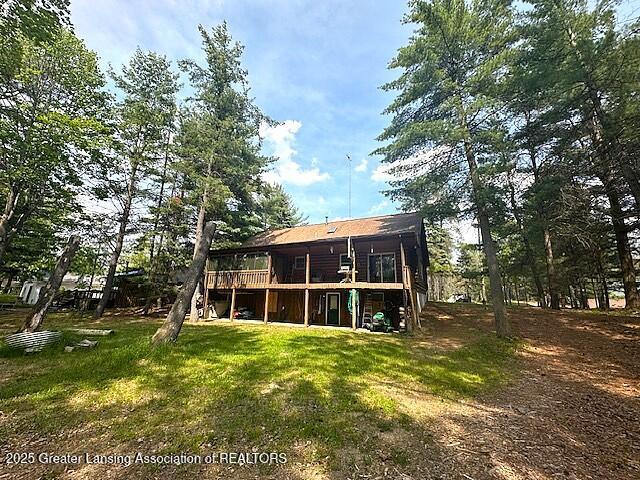 10886 SE Gillow Rd, Fife Lake, MI 49633 - back of property with a wooden deck and a lawn