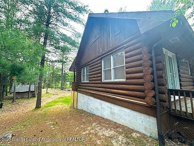 10886 SE Gillow Rd, Fife Lake, MI 49633 - view of side of property with log siding and crawl space