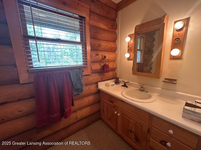 10886 SE Gillow Rd, Fife Lake, MI 49633 - bathroom featuring log walls and vanity