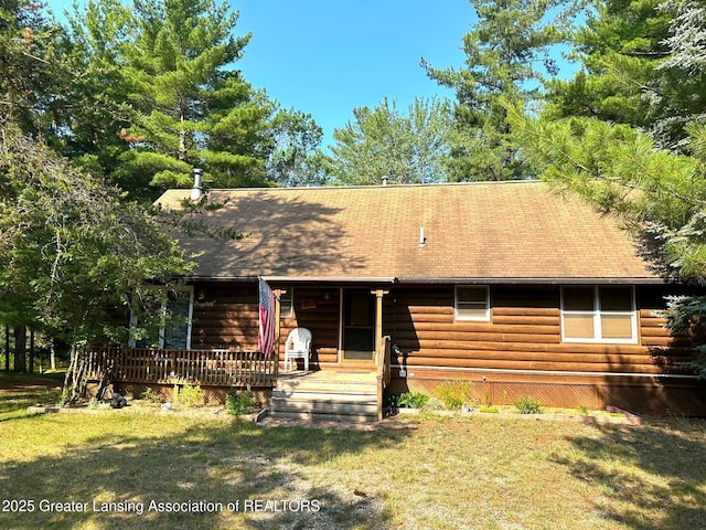 10886 SE Gillow Rd, Fife Lake, MI 49633 - view of front of property featuring log siding, a front lawn, and roof with shingles