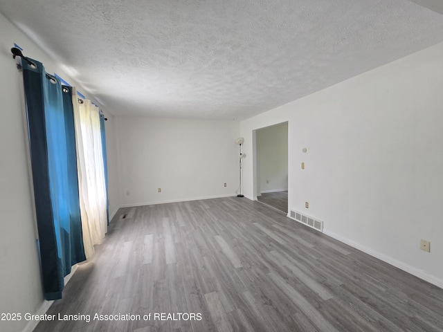 3116 Colchester Rd, Lansing, MI 48906 - empty room with a textured ceiling and wood finished floors