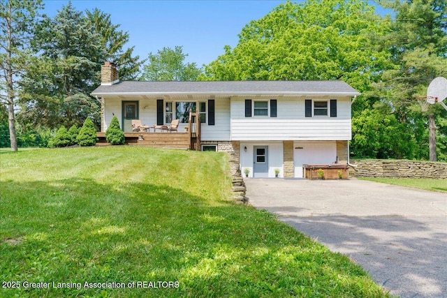 1754 S College Rd, Mason, MI 48854 - view of front of property featuring a chimney, driveway, a front lawn, an attached garage, and covered porch