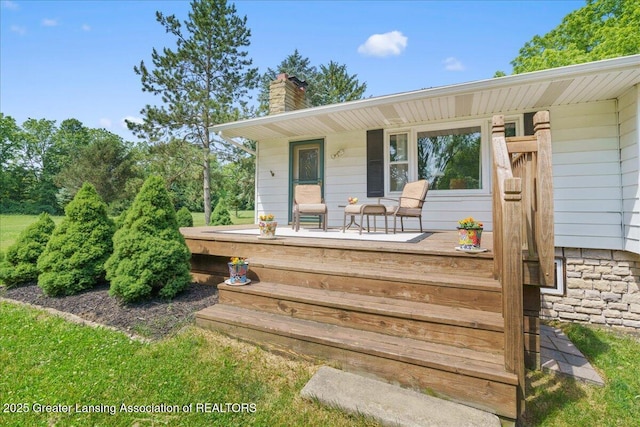 1754 S College Rd, Mason, MI 48854 - view of exterior entry featuring a porch and a chimney