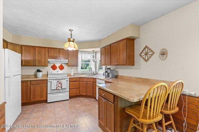 1754 S College Rd, Mason, MI 48854 - kitchen with white appliances, a peninsula, under cabinet range hood, and brown cabinets