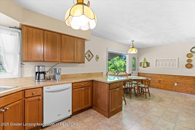 1754 S College Rd, Mason, MI 48854 - kitchen featuring white dishwasher, brown cabinets, light countertops, and a peninsula