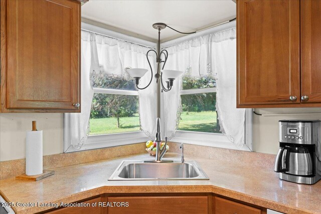 1754 S College Rd, Mason, MI 48854 - kitchen featuring light countertops, brown cabinets, and pendant lighting