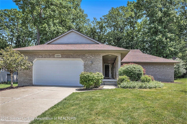 5800 Bent Tree Dr, East Lansing, MI 48823 - ranch-style home featuring brick siding, driveway, a garage, a front yard, and roof with shingles