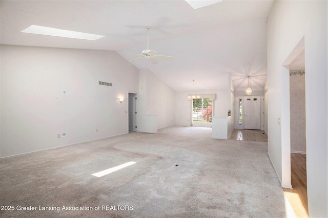 5800 Bent Tree Dr, East Lansing, MI 48823 - unfurnished living room with a skylight, light colored carpet, ceiling fan, a chandelier, and high vaulted ceiling