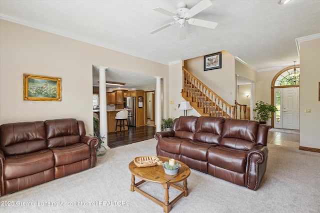169 Mapleview Dr, Charlotte, MI 48813 - carpeted living area with ornate columns, a ceiling fan, crown molding, and stairs