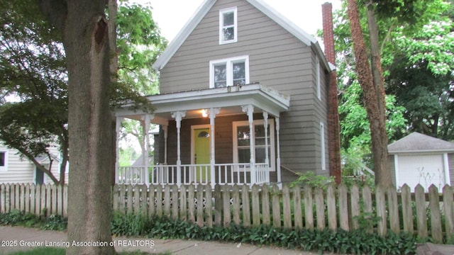 416 E Elm St, Mason, MI 48854 - view of front of property with a porch, a fenced front yard, and a chimney