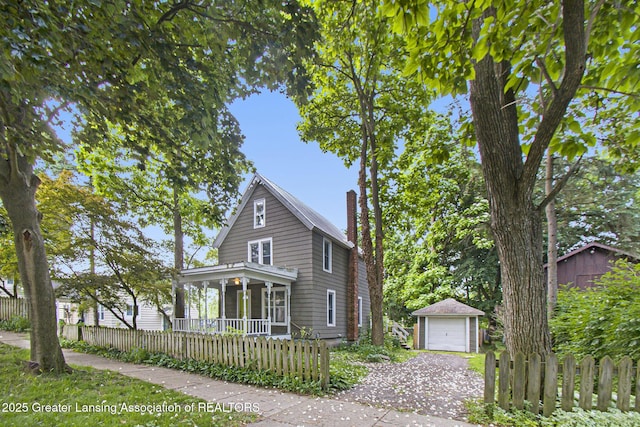 416 E Elm St, Mason, MI 48854 - traditional-style home featuring an outdoor structure, covered porch, a chimney, a garage, and gravel driveway