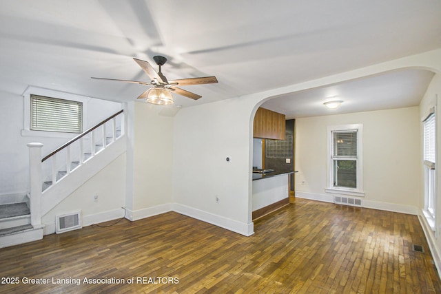 416 E Elm St, Mason, MI 48854 - unfurnished living room with arched walkways, wood-type flooring, stairway, and ceiling fan