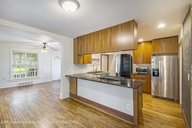 416 E Elm St, Mason, MI 48854 - kitchen featuring stainless steel appliances, brown cabinets, dark countertops, and recessed lighting