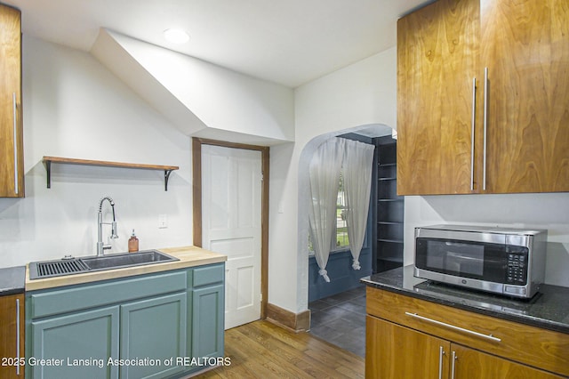 416 E Elm St, Mason, MI 48854 - kitchen featuring stainless steel microwave, open shelves, and wood finished floors