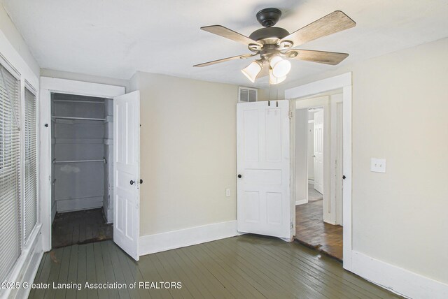 416 E Elm St, Mason, MI 48854 - unfurnished bedroom with dark wood-style floors, a closet, and ceiling fan