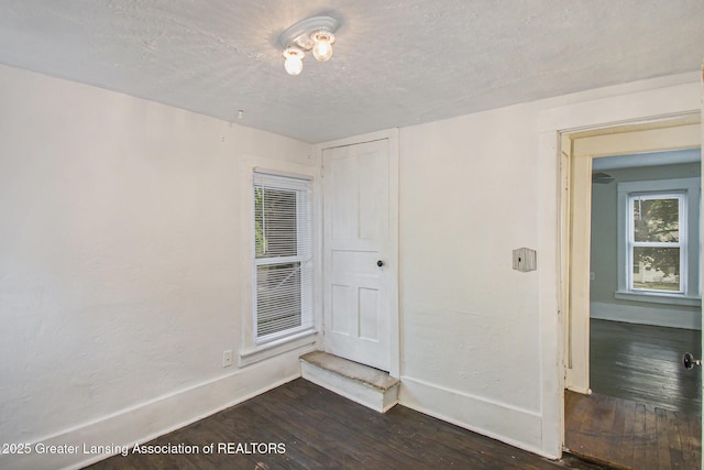 416 E Elm St, Mason, MI 48854 - spare room with dark wood-style flooring and a textured ceiling
