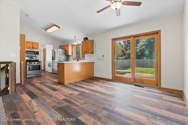 1313 W Alward Rd, Dewitt, MI 48820 - kitchen featuring stainless steel appliances, a peninsula, brown cabinets, dark wood-style flooring, and lofted ceiling