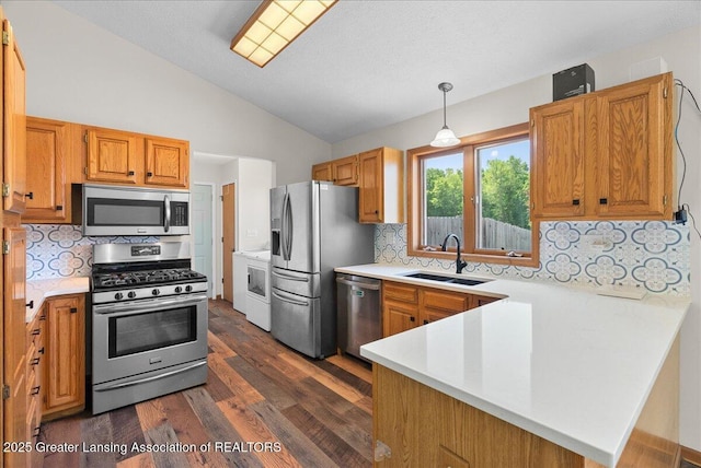 1313 W Alward Rd, Dewitt, MI 48820 - kitchen featuring appliances with stainless steel finishes, a peninsula, vaulted ceiling, light countertops, and dark wood-style floors