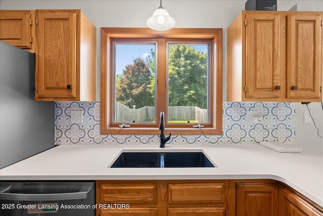 1313 W Alward Rd, Dewitt, MI 48820 - kitchen with stainless steel dishwasher, light countertops, backsplash, and hanging light fixtures