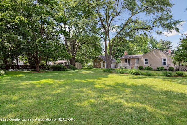 6244 Daft St, Lansing, MI 48911 - view of green lawn featuring a storage shed