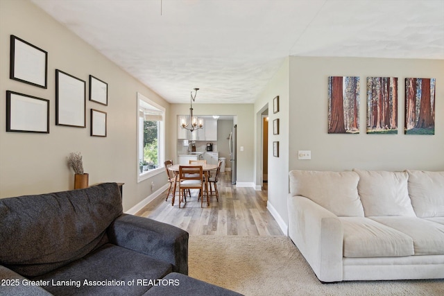 6244 Daft St, Lansing, MI 48911 - living area with a chandelier and light wood-style flooring