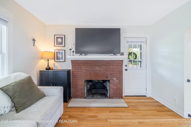 308 Memphis St, Lansing, MI 48915 - living area featuring wood finished floors and a brick fireplace