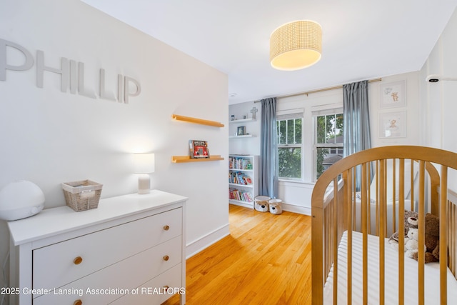308 Memphis St, Lansing, MI 48915 - bedroom featuring light wood-type flooring and a crib