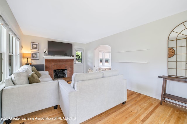 308 Memphis St, Lansing, MI 48915 - living area with arched walkways, wood finished floors, and a fireplace