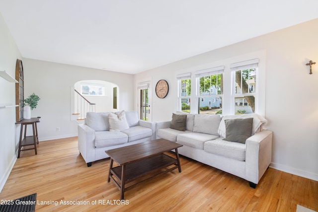 308 Memphis St, Lansing, MI 48915 - living room with light wood-style flooring, arched walkways, and stairs