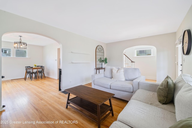 308 Memphis St, Lansing, MI 48915 - living area with arched walkways, a chandelier, plenty of natural light, and light wood finished floors