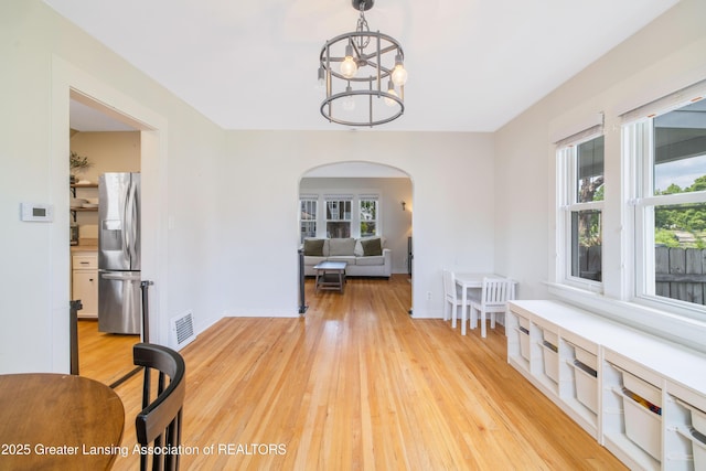 308 Memphis St, Lansing, MI 48915 - dining room with arched walkways, light wood-style flooring, and a chandelier