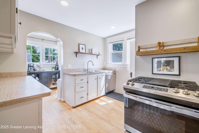 308 Memphis St, Lansing, MI 48915 - kitchen with appliances with stainless steel finishes, white cabinets, healthy amount of natural light, arched walkways, and recessed lighting