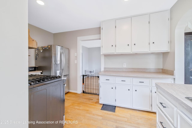 308 Memphis St, Lansing, MI 48915 - kitchen with appliances with stainless steel finishes, arched walkways, white cabinets, light countertops, and recessed lighting