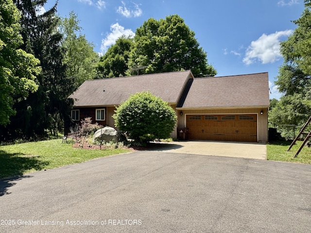12830 Upton Rd, Bath, MI 48808 - view of front of house featuring asphalt driveway, a garage, and a front yard