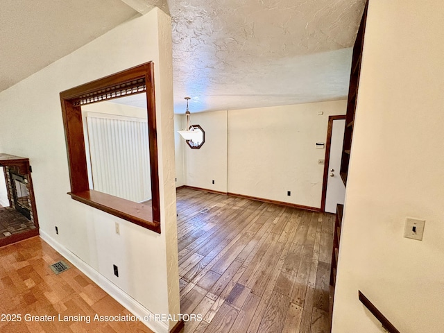 12830 Upton Rd, Bath, MI 48808 - corridor featuring hardwood / wood-style flooring and a textured ceiling