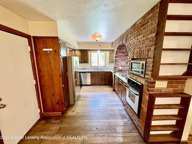 12830 Upton Rd, Bath, MI 48808 - kitchen with appliances with stainless steel finishes, light wood-style floors, and light countertops