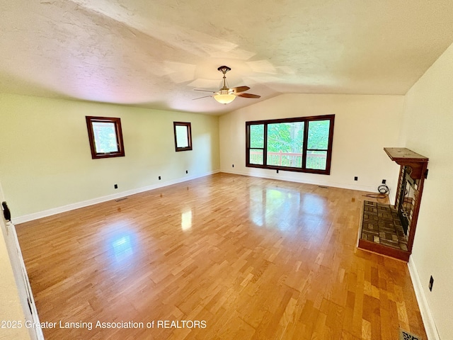 12830 Upton Rd, Bath, MI 48808 - unfurnished living room featuring ceiling fan, light wood finished floors, lofted ceiling, and a textured ceiling