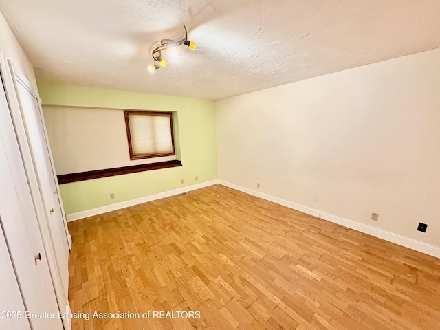 12830 Upton Rd, Bath, MI 48808 - empty room featuring light wood-style flooring and a textured ceiling