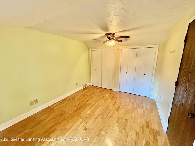 12830 Upton Rd, Bath, MI 48808 - unfurnished bedroom with light wood-style floors, multiple closets, and ceiling fan