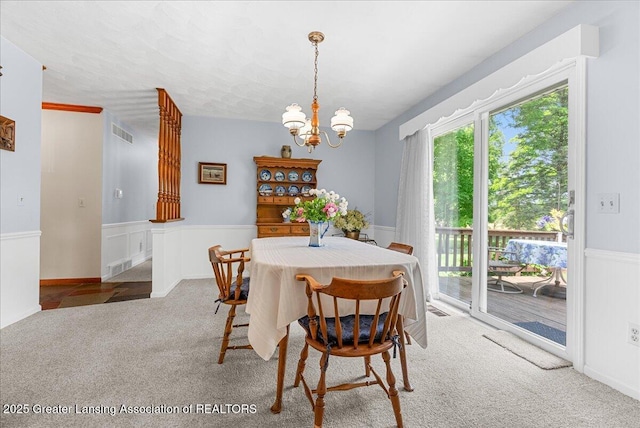 10648 Bobsyl Ln, Grand Ledge, MI 48837 - carpeted dining room featuring a chandelier and wainscoting